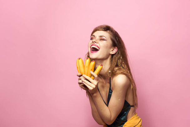 Hermosa mujer con plátanos en las manos sombrero de paja emociones fondo rosa - Foto, imagen
