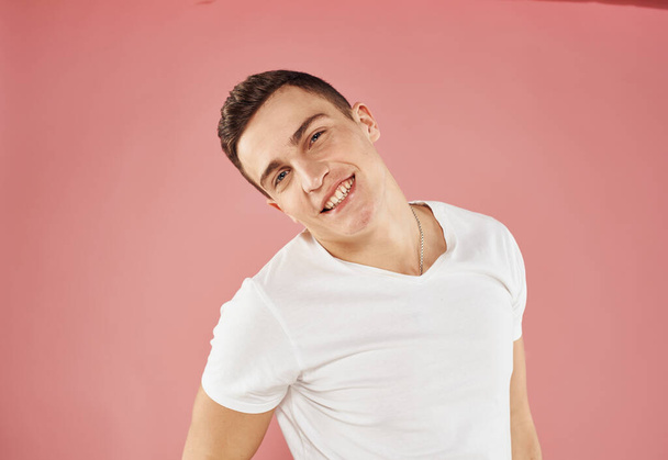 Lindo hombre y blanco camiseta mano gesto emociones rosa fondo - Foto, Imagen