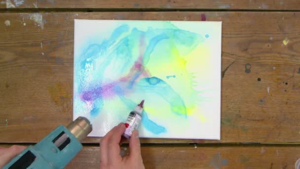 Fluid Art. Abstract painting. Top view of two professional artist paints an abstract picture. They uses water spray and dryer - Footage, Video