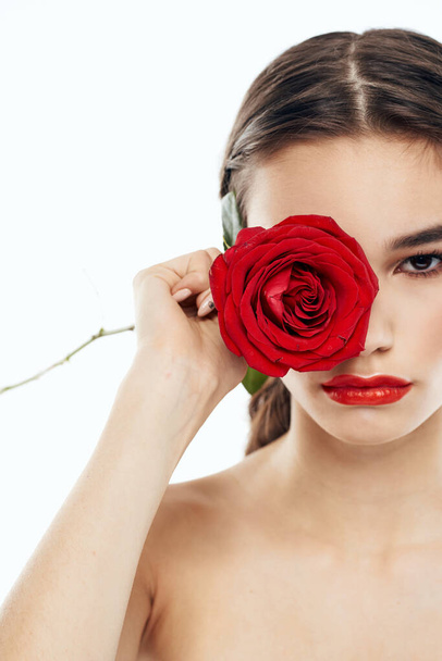 Женщина с красной розой в руках и макияж тени для глаз модель голые плечи обрезанный вид - Фото, изображение