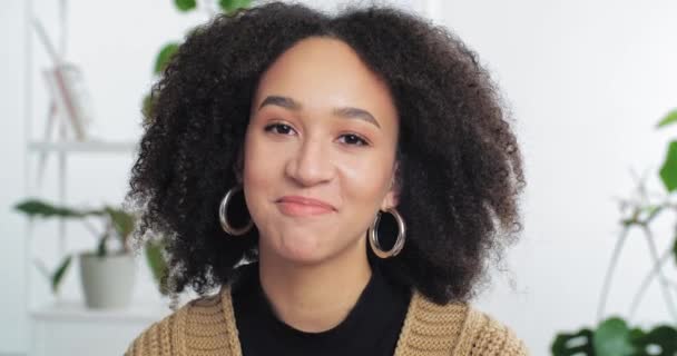 Χαμογελώντας African American hipster κορίτσι φοιτητής με Afro στυλ μαλλιών κοιτάζοντας κάμερα μιλώντας με την κάμερα με τον φίλο σε απευθείας σύνδεση κάνοντας βιντεοκλήση, εικονική συνομιλία, καταγραφή blog vlog, πορτρέτο headshot - Πλάνα, βίντεο