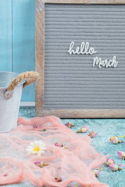 Γεια σας αφίσα Μαρτίου με ροζ μαντήλι και άνθη λουλουδιών γύρω. Υψηλής ποιότητας φωτογραφία - Φωτογραφία, εικόνα