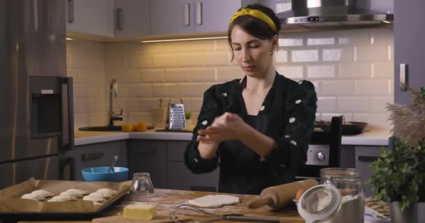 Belle donne che preparano torta in una cucina accogliente a casa su un tavolo di legno. Lavoro domestico e concetto di hobby. - Filmati, video