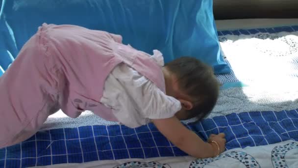 Střední záběr malého dítěte, jak si hraje, stojí současně na pažích a nohou - Záběry, video