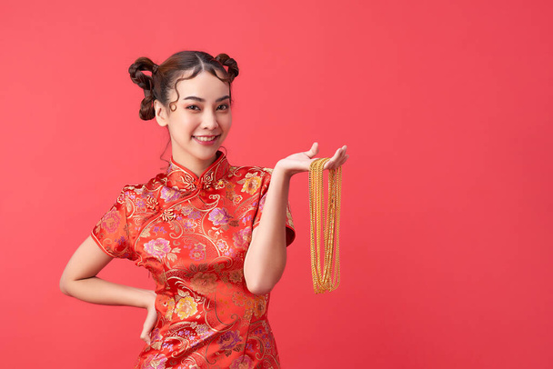 Приваблива жінка азійського походження в традиційному вбранні тримає золоте намисто з радістю і веселим. Китайський щасливий новий рік. Поняття бажання. - Фото, зображення