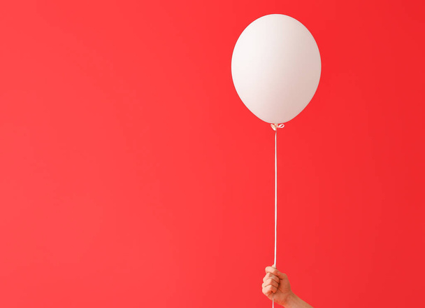 Menselijke hand met luchtballon op kleur achtergrond - Foto, afbeelding