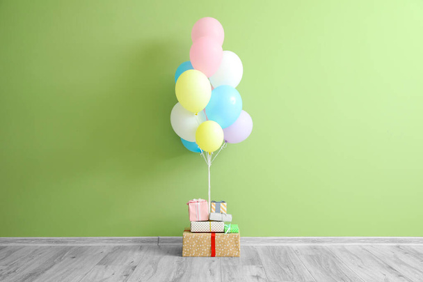 Vzduchové balónky s dárky v blízkosti barevné stěny - Fotografie, Obrázek