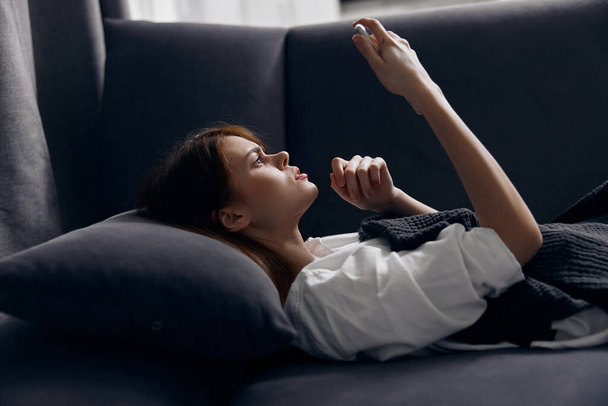mujer con teléfono móvil tumbado en el sofá en el interior - Foto, Imagen