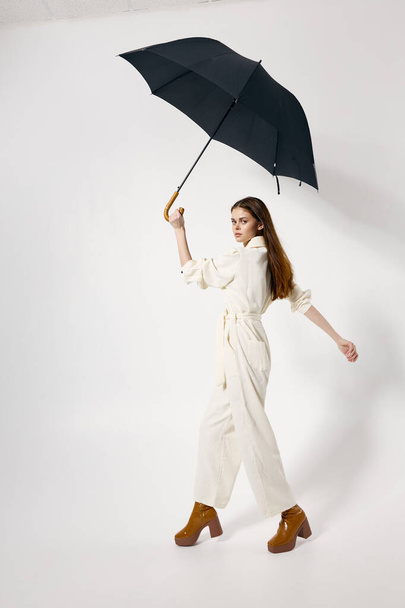 csinos nő overálban nyitott esernyővel séta - Fotó, kép