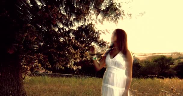Fiatal lány öltözött fehér érintő levelek a mágikus fa lassú mozgás - Felvétel, videó
