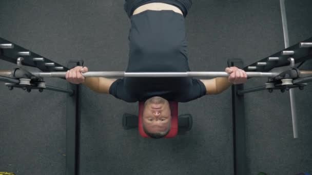 Sportowiec w siłowni podnosi sztangę - Materiał filmowy, wideo