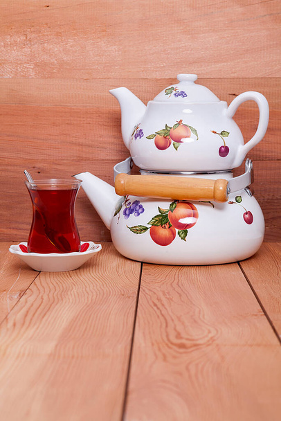 Ahşap zeminde çaydanlık ve bir fincan çay.. - Fotoğraf, Görsel