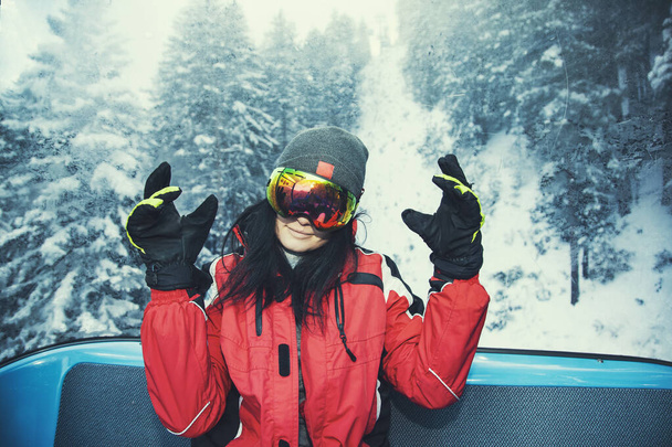 πορτρέτο της νεαρής όμορφης γυναίκας που ποζάρει στο κοστούμι snowboarder  - Φωτογραφία, εικόνα