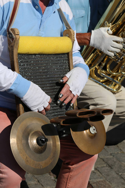 уличный музыкант играет на самодельном инструменте, прижимая наперстками к металлической поверхности, издающей звуки - Фото, изображение