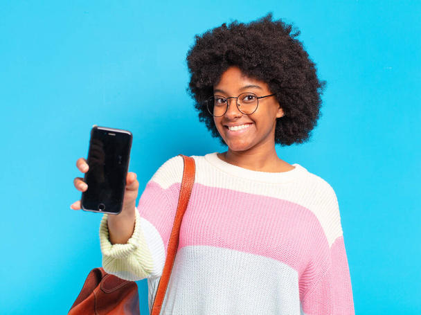 fiatal csinos afro diák nő egy okos telefon - Fotó, kép