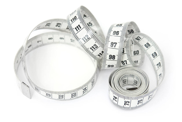 Onopgerolde spiraalvormige kleermakersband maatregel geïsoleerd op witte achtergrond - Foto, afbeelding