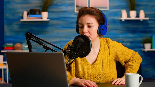 Kuuluisa bloggaaja avaamalla kannettava tietokone ja lukeminen ääneen mikrofonissa - Valokuva, kuva