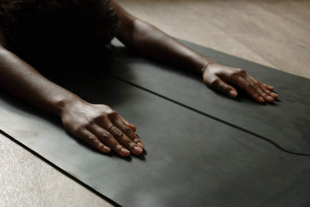 Primo piano di yoga femminile che si allunga durante il flusso di yoga praticando posizioni in lounge moderno  - Foto, immagini