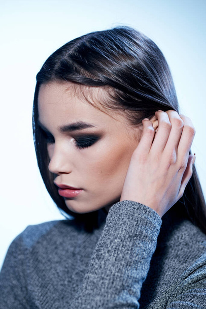 Портрет брюнетки в сером свитере и тени для глаз вечерний макияж - Фото, изображение