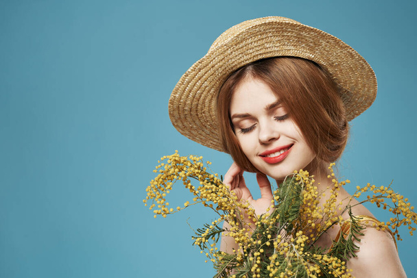 Όμορφη γυναίκα σε μπουκέτο καπέλο λουλούδια γοητεία μπλε φόντο - Φωτογραφία, εικόνα