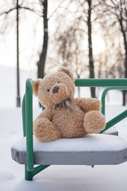 El oso de juguete fue dejado en el invierno en el parque infantil. - Foto, Imagen