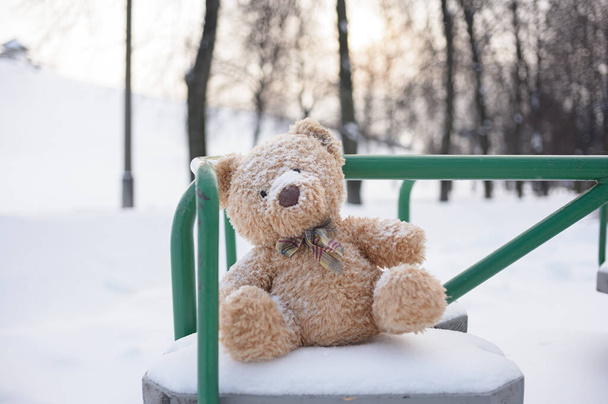 Der Spielzeugbär wurde im Winter auf dem Kinderspielplatz zurückgelassen - Foto, Bild
