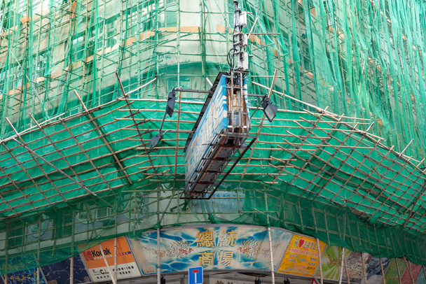Causeway Bay, Hong Kong Island, China, Asia - Building wrapped in traditional Chinese scaffolding made of bamboo. - Photo, Image