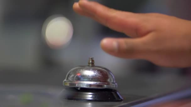 Χέρι χτυπάει ασημένια counter bell με θολή φόντο - Πλάνα, βίντεο