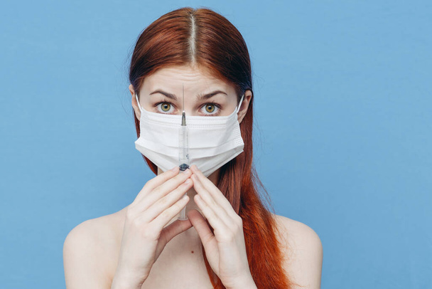 woman in medical mask holds syringe in hand and bare shoulders botox injection - Zdjęcie, obraz