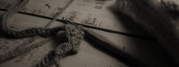 На рустикальном столе, бобины из ниток и шерсти, чтобы создать узоры и вязаные вещи ручной работы - Фото, изображение