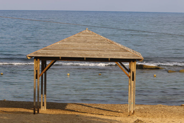 Baldachin zum Schutz vor der Sonne und zur Erholung im Freien am Ufer des Mittelmeers im Norden Israels  - Foto, Bild