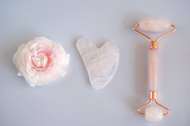 Pink Gua Sha stone and roller for massage and flower - Photo, Image
