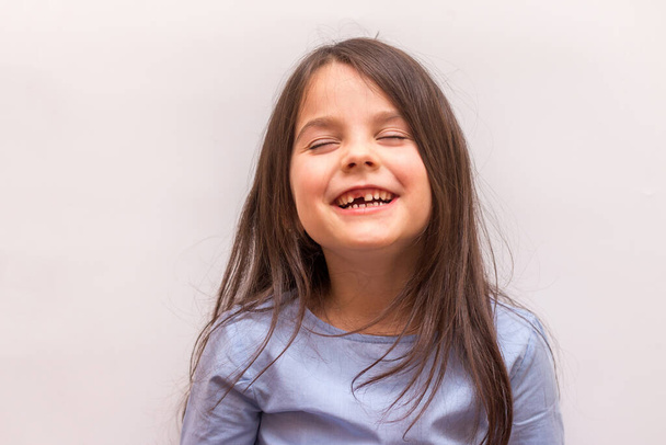 Mosolygó spanyol kislány elülső fog nélkül fehér stúdió háttér - Fotó, kép