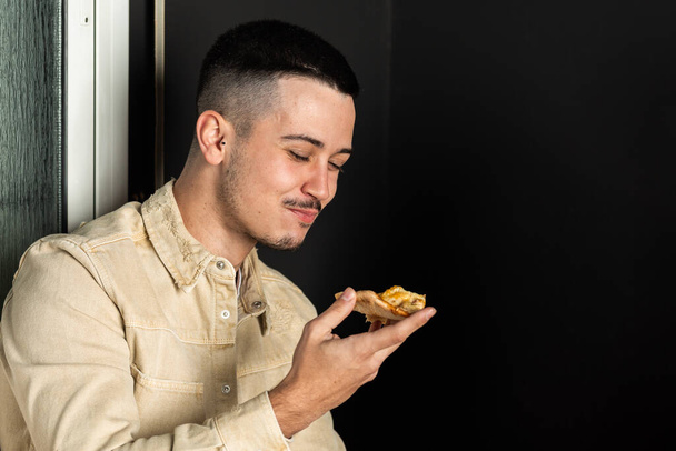 Bıyıklı beyaz adam bir dilim pizza yiyor. - Fotoğraf, Görsel