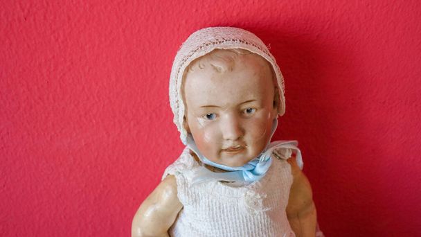 kleine alte Puppe aus dem letzten Jahrhundert, die nach einem Sturz oder gewalttätigem Spiel angepasst wurde - Foto, Bild
