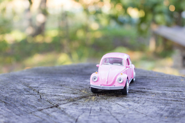 Pink toy car on a wooden stump - Photo, Image