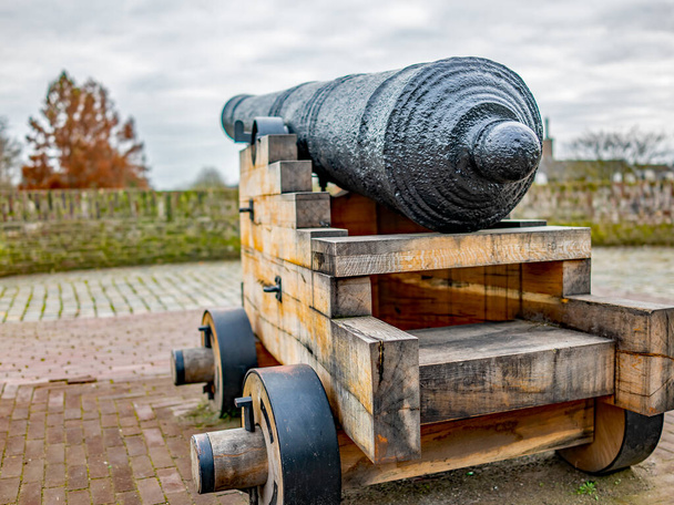 Закрытие изолированного канона на деревянной подставке на городской стене города Фастрия, Нидерланды - Фото, изображение