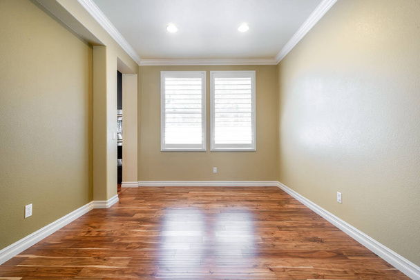 Bright beige gran habitación vacía con suelo de madera, molduras y ventanas. - Foto, imagen