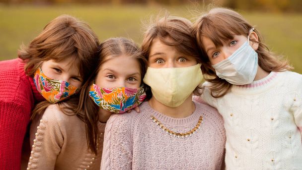 Grupo de cuatro novias en edad escolar con máscaras protectoras esperan el fin del bloqueo pandémico y regresan al estilo de vida normal - Foto, Imagen