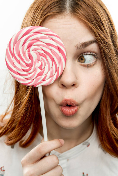 Frau mit offenem Mund hält Lutscher nahe Gesicht Süßigkeiten Freude Emotionen - Foto, Bild
