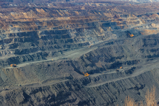 Pedreira de minério de ferro enorme com caminhões e escavadeiras de descarga de trabalho - Foto, Imagem