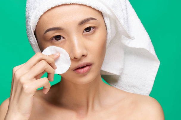 Mujer asiática hombros desnudos piel clara maquillaje eliminación - Foto, imagen
