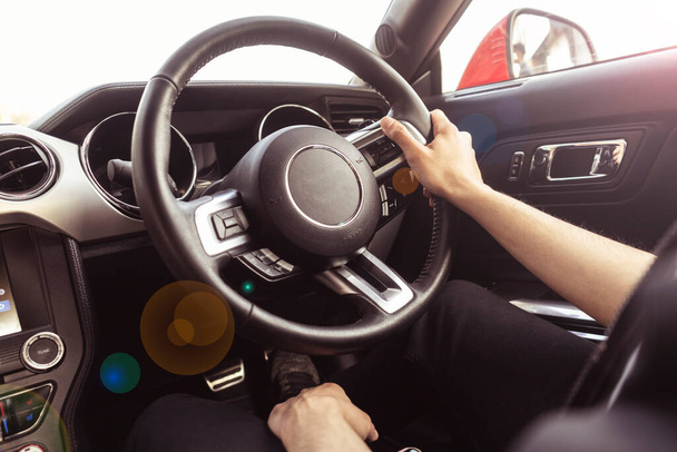 Primer plano de las manos sosteniendo el volante de un coche. Interior de un coche de lujo. - Foto, imagen