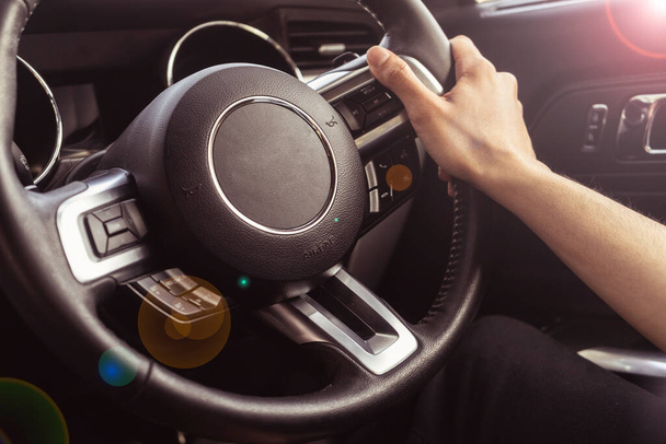 Primer plano de las manos sosteniendo el volante de un coche. Interior de un coche de lujo. - Foto, imagen