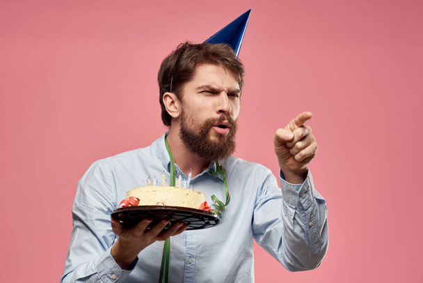 Uomo barbuto con torta su sfondo rosa festa di compleanno aziendale emozioni modello solitudine - Foto, immagini