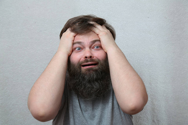 Un hombre con barba en rabieta Expresión facial de pánico, miedo, fracaso Concepto: quiebra, quiebra, estrés, derrota. Humor, una broma. - Foto, Imagen