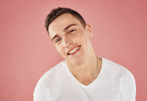 Muotokuva iloinen kaveri vaaleanpunainen tausta rajattu näkymä valkoinen t-paita tunteita - Valokuva, kuva