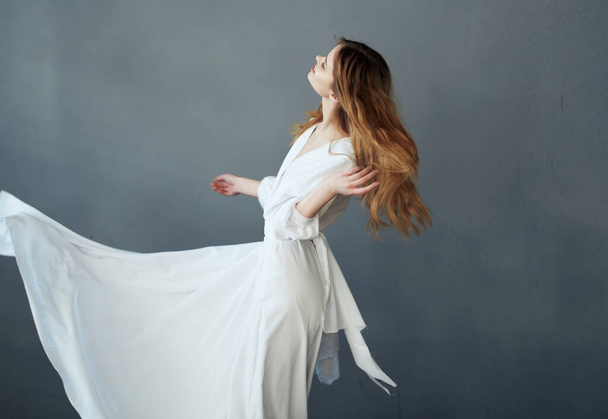 Mujer en vestido blanco atractivo espectáculo glamour rendimiento fondo gris - Foto, Imagen