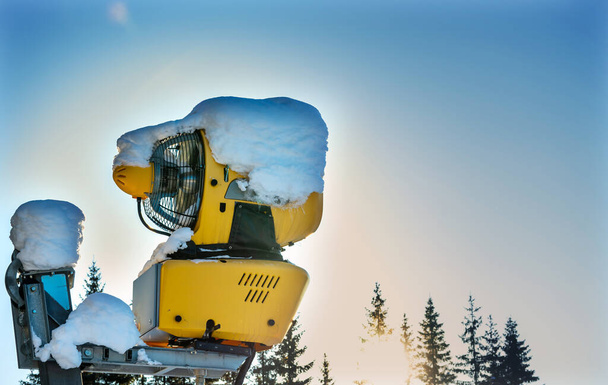 Güneşli bir kış gününde kayak merkezinde kar yapma makinesi. Yüksek kalite fotoğraf - Fotoğraf, Görsel