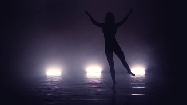 Young beautiful contemporary  ballerina on smoke stage dancing modern ballet - 写真・画像